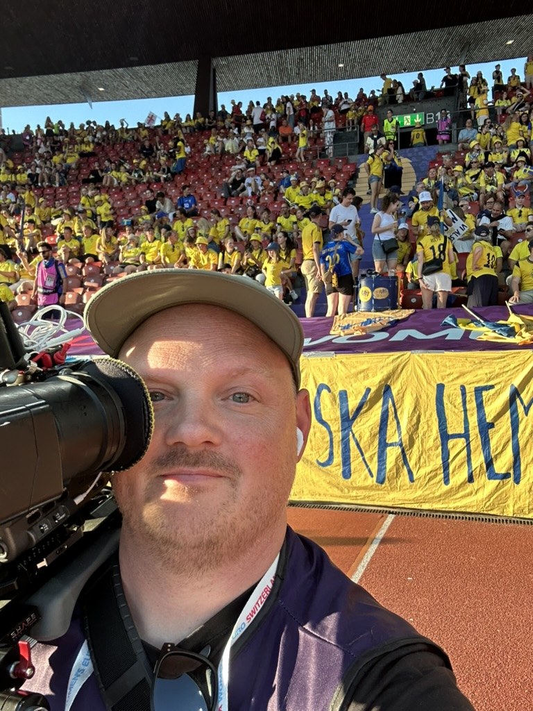 Med kameran framför svenska supportrar på friidrottsmästerskap