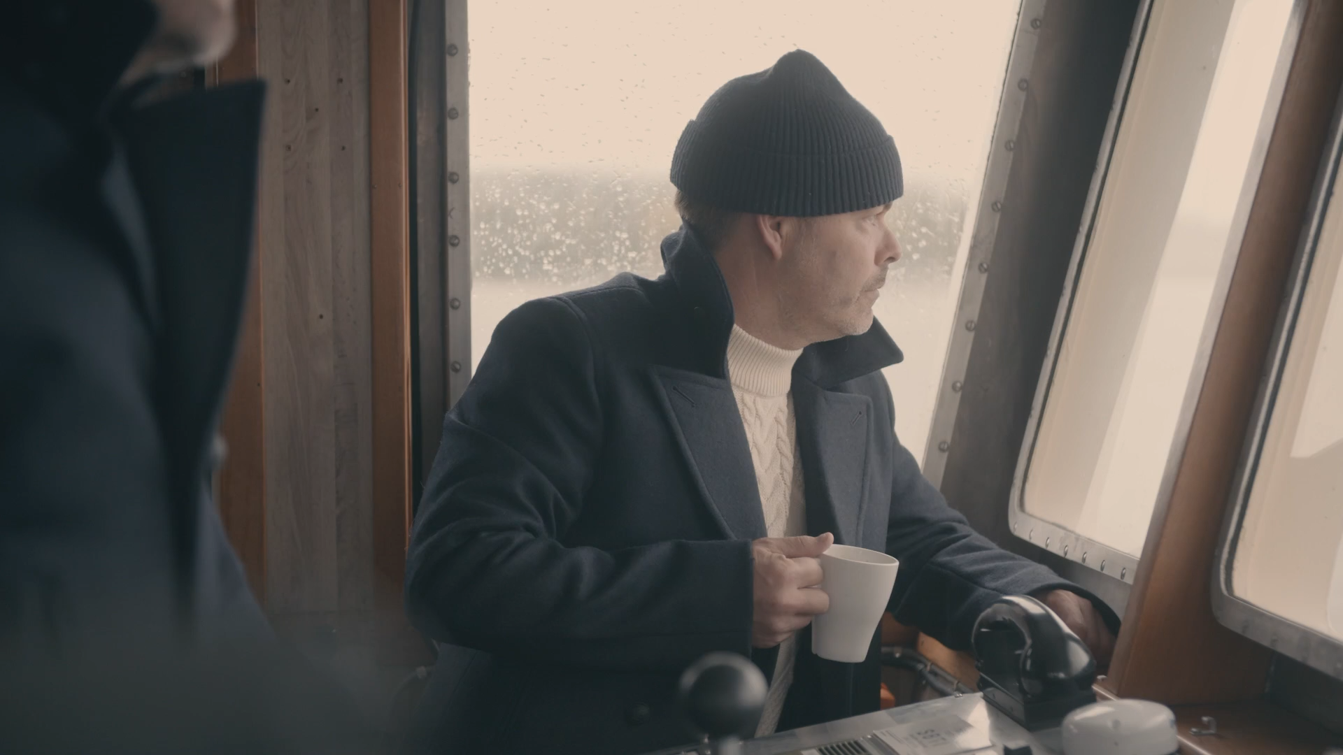 Man med kaffekopp ombord på en båt