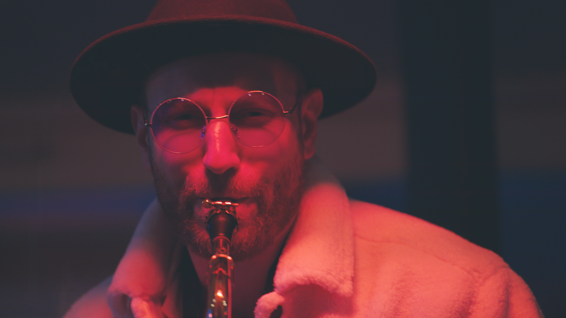Saxofonist i dramatiskt rött ljus